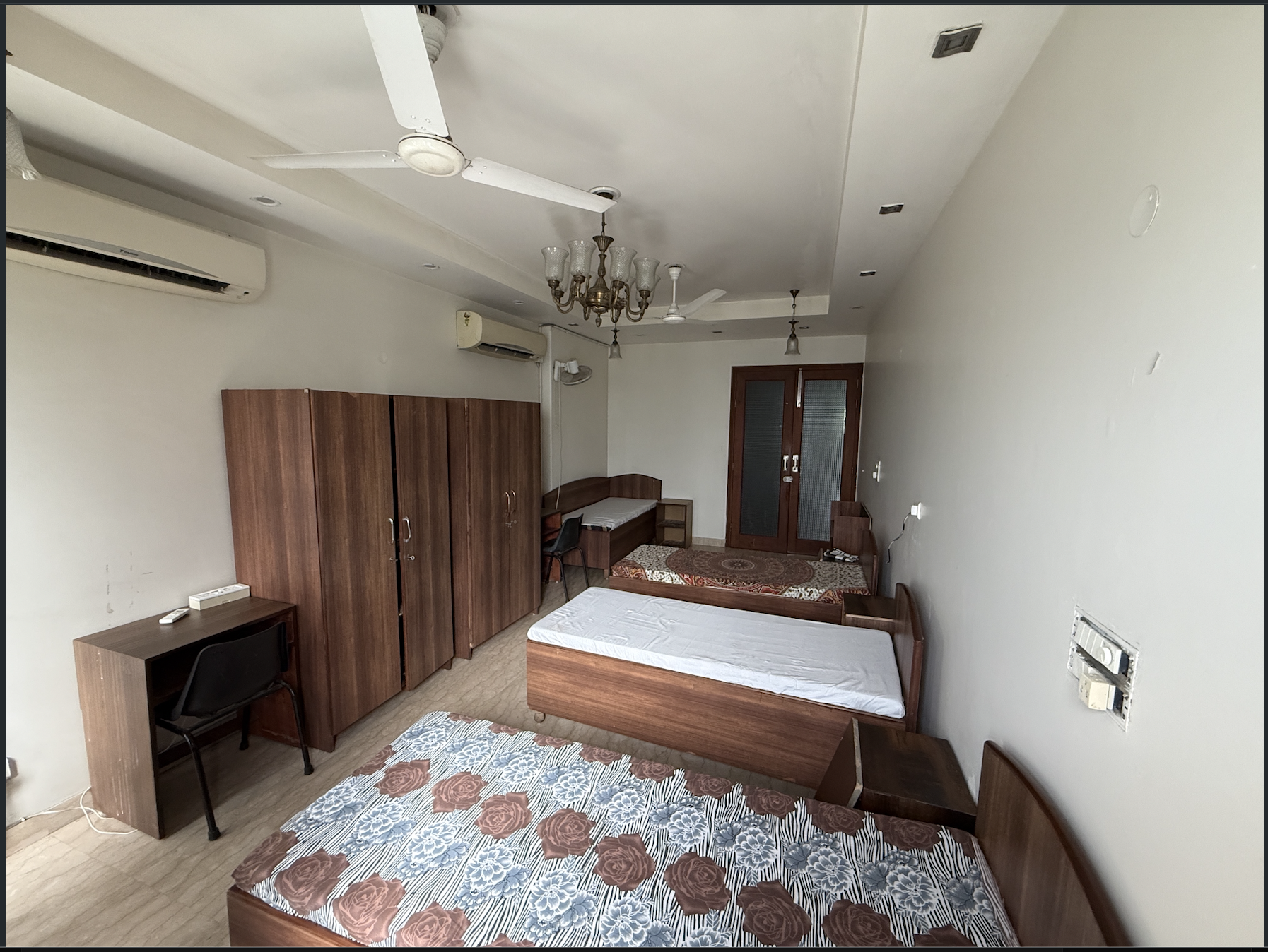 Spacious shared room with beds, wardrobes and study desk